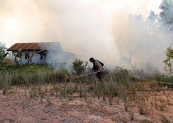 Ilustrasi anggota polisi memadamkan api pada lahan kering yang terbakar di Kota Dumai Riau Foto Utusan Bangsa