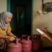 Ilustrasi warga sedang membeli elpiji atau mencatat meteran listrik di rumah sederhana