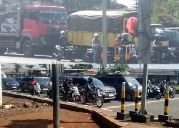 Suasana arus lalu lintas di perempatan Cileungsi yang dipadati kendaraan roda dua, truk, dan mobil pribadi.