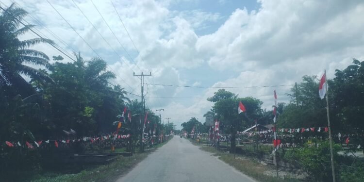 Suasana semarak di salah satu ruas jalan di Kecamatan Bunga Raya Siak yang dihiasi dengan bendera Merah Putih dan umbul umbul untuk menyambut HUT Kemerdekaan RI ke 80