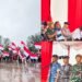 Suasana Gerakan Pembagian Bendera Merah Putih 2025 di Dumai Sabtu 1082025 Ratusan warga bersama unsur Forkopimda TNI Polri dan pemerintah daerah membentangkan dan mengibarkan Sang Merah Putih di tengah hujan