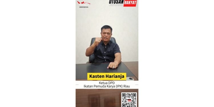 Kasten Harianja Ketua DPD Ikatan Pemuda Karya IPK Riau yang duduk di belakang meja dengan ekspresi bersemangat