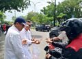 Ketua PWI Riau Raja Isyam Azwar berkacamata kemeja putih bersama pengurus PWI Riau membagikan paket nasi dan minuman kepada pengendara dalam kegiatan Jumat Berkah di depan Kantor PWI Riau Jalan Arifin Achmad Pekanbaru Jumat 1292025
